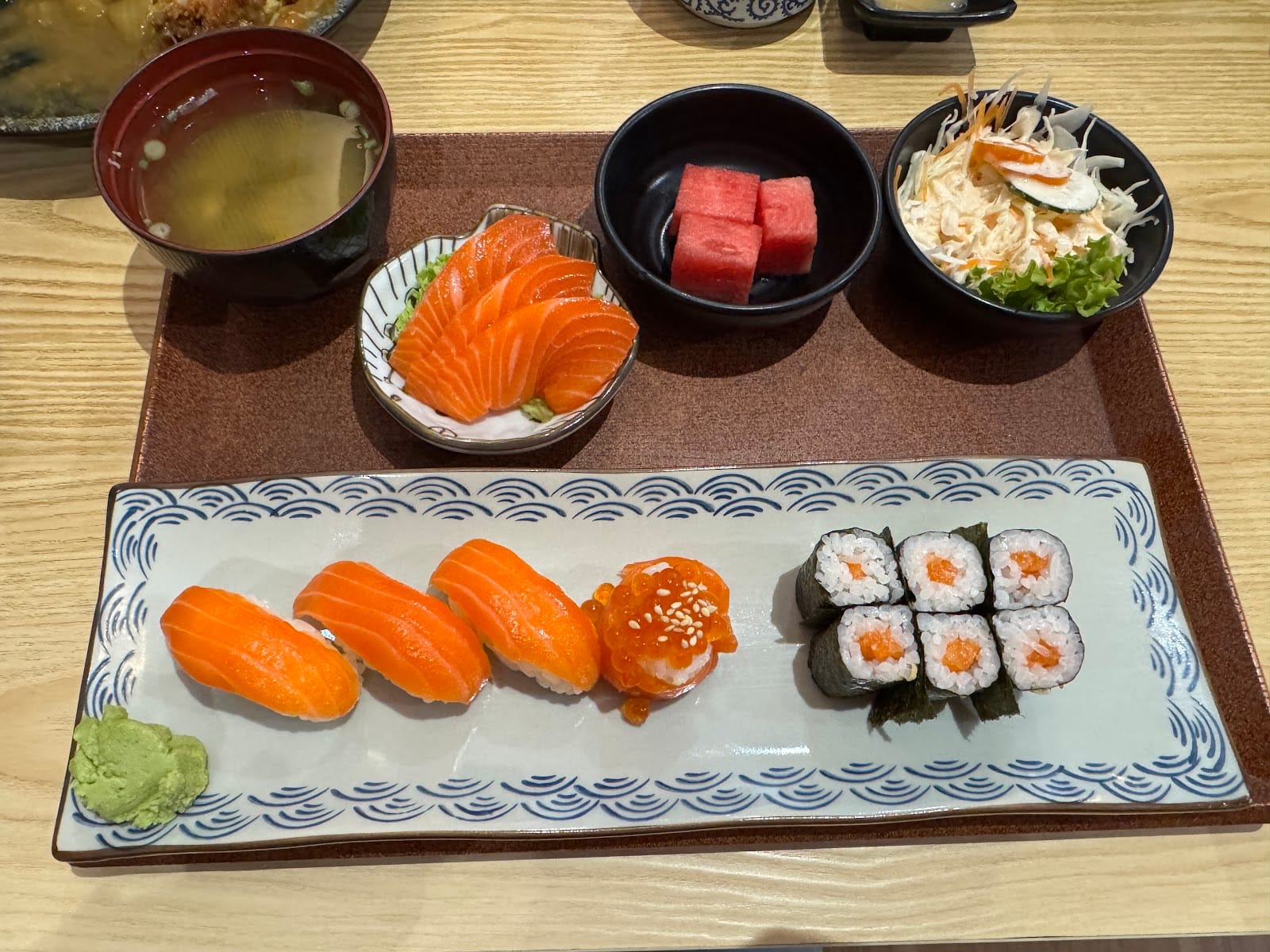 Salmon sushi set: nigiri, salmon roe gunkan, maki and sashimi with miso soup, salad and watermelon
